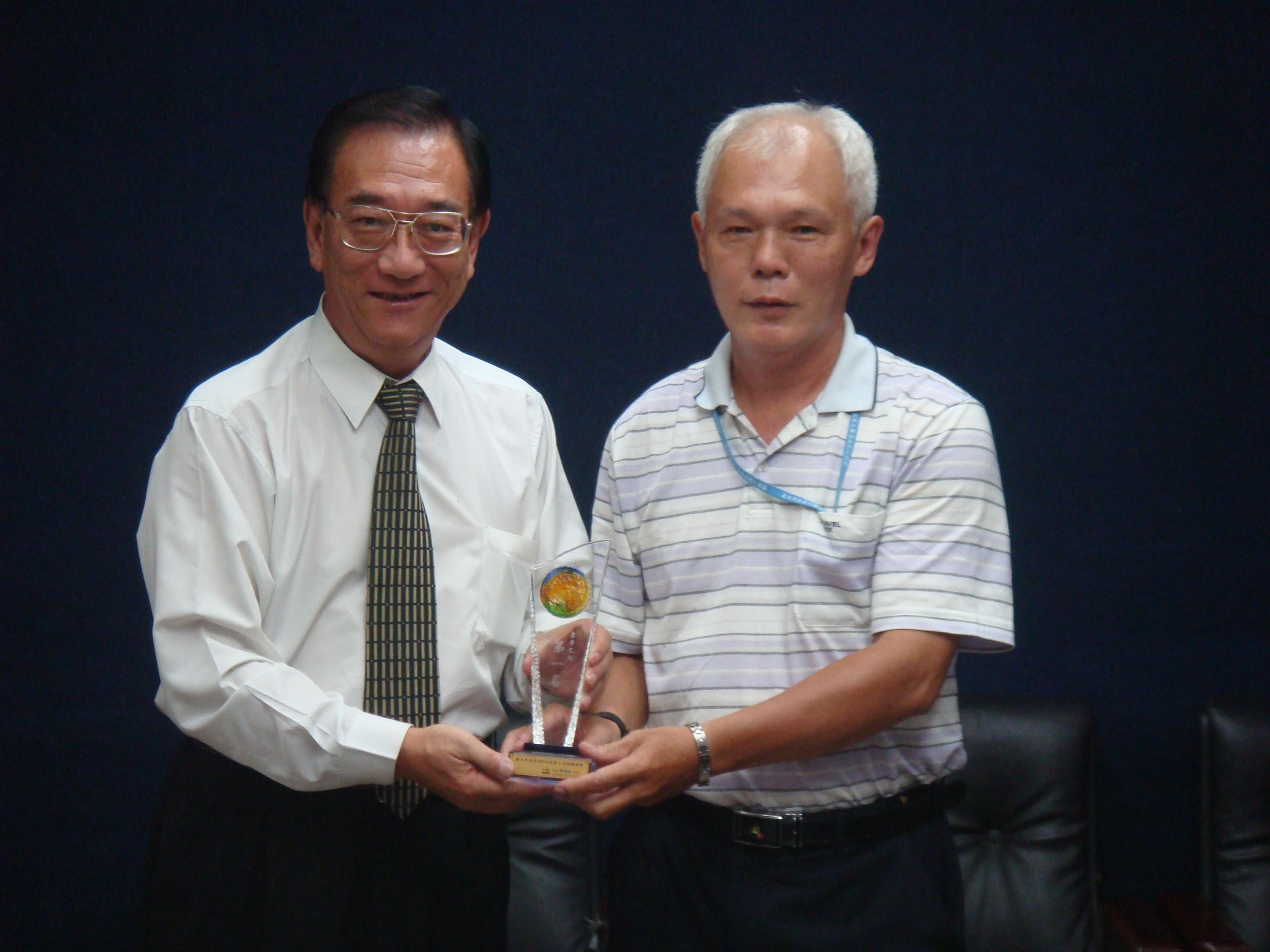Team representative, Xu Zhi-Hong, presenting the honor to the Commissioner of the Department